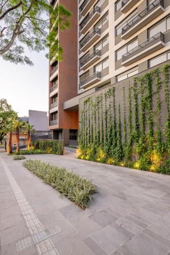 a building with a wall with plants in front of it at Skyline Parque Moinhos by LikeHome in Floresta