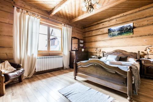 a bedroom with wooden walls and a bed and a window at Apartament Kalina-Mocarni in Kościelisko