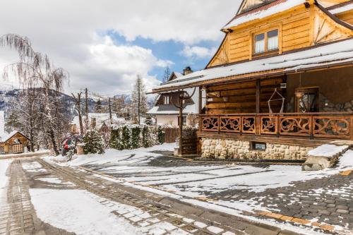 a wooden house on a snow covered street at Apartament Kalina-Mocarni in Kościelisko