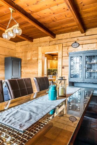 a dining room with a table and leather chairs at Apartament Kalina-Mocarni in Kościelisko