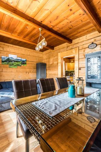 a living room with a table and leather chairs at Apartament Kalina-Mocarni in Kościelisko