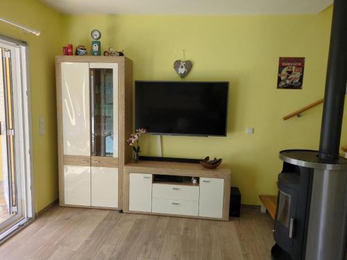 Villa Green Oasis في بوريتش: غرفة معيشة مع تلفزيون بشاشة مسطحة على الحائط