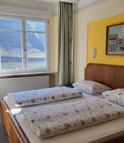 two beds in a bedroom with a window at Hotel Mosel-Landhaus in Briedern
