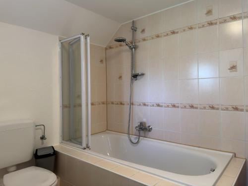 Un baño con bañera, inodoro y ducha. en Ferienhaus, Friederikensiel, en Friederikensiel