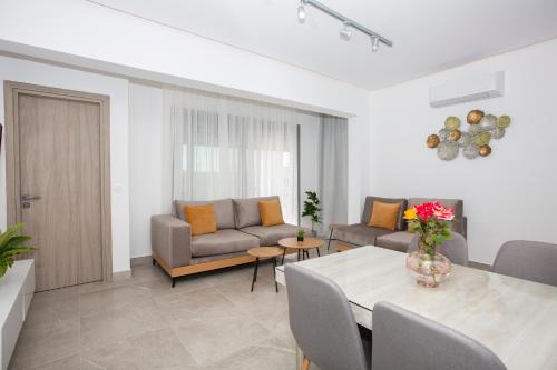 a living room with a table and a couch at RENI APARTMENT Faliraki in Faliraki