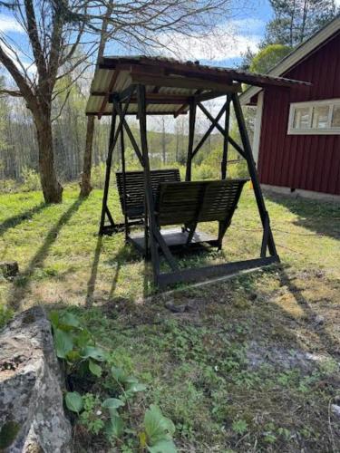 a park bench with a gazebo in a yard at Hus Björklund in Hällefors