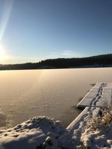 a dock in the snow next to a body of water at Hus Björklund in Hällefors