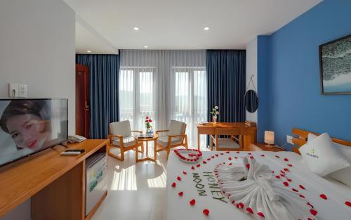 a bedroom with a bed and a living room at Stellar Hotel Phú Quốc in Phu Quoc
