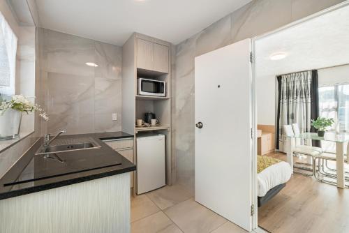 a kitchen with a sink and a counter top at Travel Air Motel in Auckland