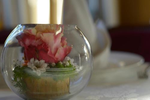 a glass bowl with flowers in it on a table at Logis Hotel Restaurant Au Boeuf Rouge in Niederschaeffolsheim