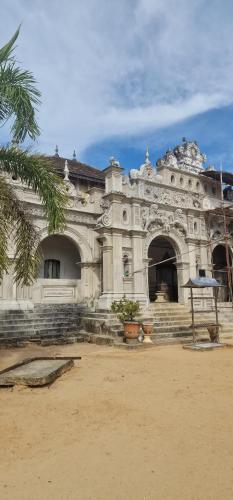 un antiguo edificio con una palmera delante de él en not, en Nikawatawana