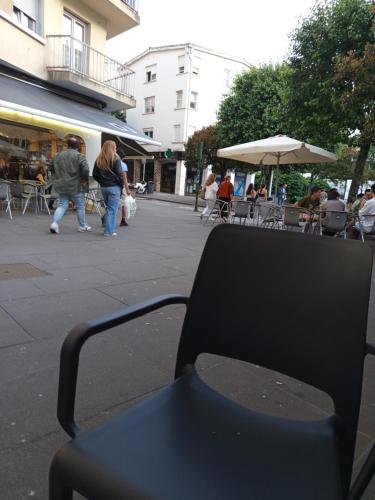 un banc assis dans une rue de la ville avec des gens qui marchent dans l'établissement Habitación de lujo, à Saint-Jacques-de-Compostelle