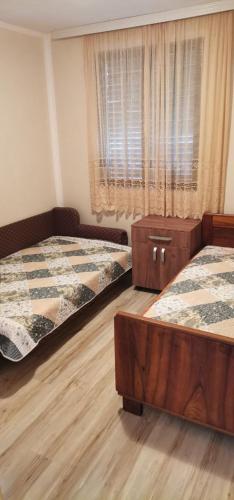 a bedroom with two beds and a window at Vikendica Pavlović in Zatonje