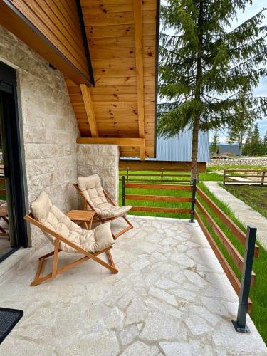 two chairs and a table on a patio at A-frame Durmitor in Žabljak
