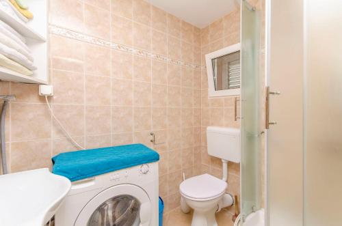 un bagno con lavatrice e WC di Apartment Kipson a Nin
