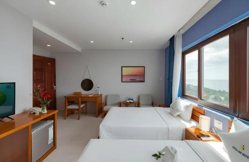 a hotel room with two beds and a tv at Stellar Hotel Phú Quốc in Phu Quoc