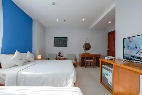 a bedroom with a bed and a flat screen tv at Stellar Hotel Phú Quốc in Phu Quoc