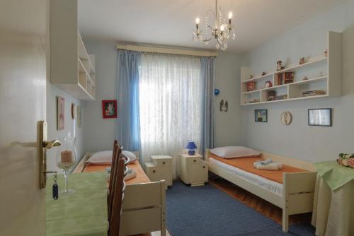 a bedroom with two beds and a window at Rooms Mirjana in Trogir