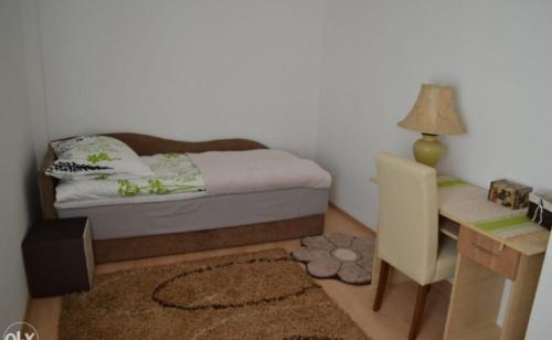 a small bedroom with a bed and a desk at Comfort A&M in Sarajevo