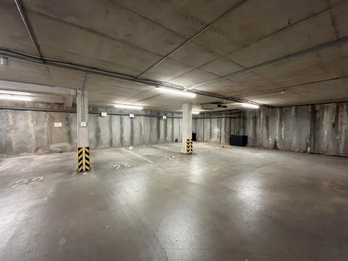 an empty parking garage with concrete walls and lights at Manchester City Centre Apt with Balcony & Free Parking in Manchester