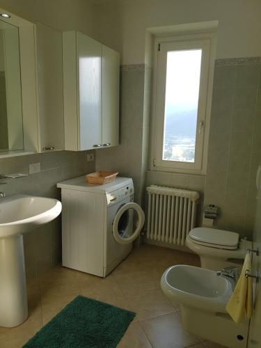 a bathroom with a toilet sink and a washing machine at Il Palazzo apartment with a view of the lake and nature in Calolziocorte