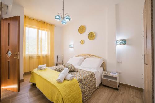 a small bedroom with two beds and a yellow blanket at casa Ferrigno in Vietri sul Mare