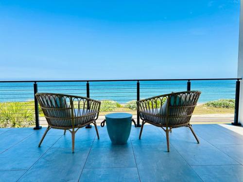 Dos sillas sentadas en un porche con vistas al océano en The C House - 3 Story, en Flagler Beach
