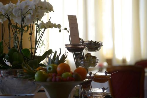 a table topped with a bowl of fruit and flowers at Logis Hotel Restaurant Au Boeuf Rouge in Niederschaeffolsheim