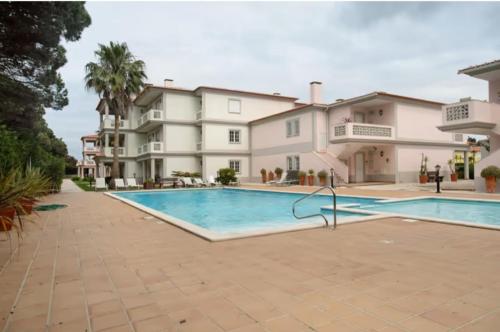 a large house with a swimming pool in front of it at Good vibes in Amoreira