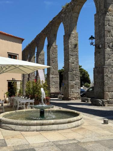 a fountain in the middle of a courtyard with arches at Villa 5 in Vila do Conde