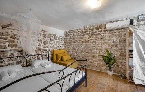 a bedroom with a bed and a yellow chair at Nice Home In Tisno With Wifi in Tisno
