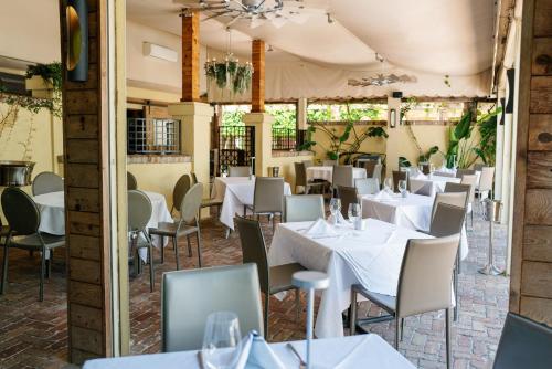 a restaurant with white tables and chairs at Hotel Escalante in Naples