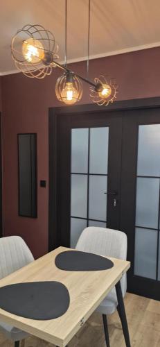 a dining room with a table and two chairs at Apartament Burgund 2 pokojowy z ogródkiem lub pokoje ze wspólną kuchnią i łazienką in Warsaw