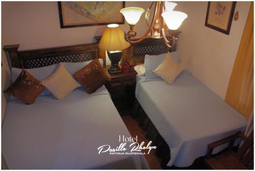 two twin beds in a room with two lamps at Hotel Rholyn Pura Vida!! in Antigua Guatemala