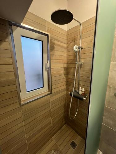 a bathroom with a shower with a window at Imangination Home in Asprópirgos