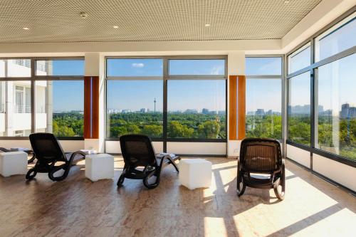 an empty waiting room with chairs and large windows at SOALTEE Hotel by Trip Inn Frankfurt Messe Tagungshotel in Frankfurt/Main