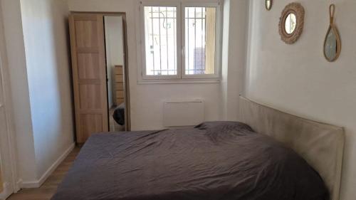 - une chambre avec un lit, une fenêtre et une porte dans l'établissement T2 calme à 11 minutes des Remparts - Wifi Parking, à Avignon