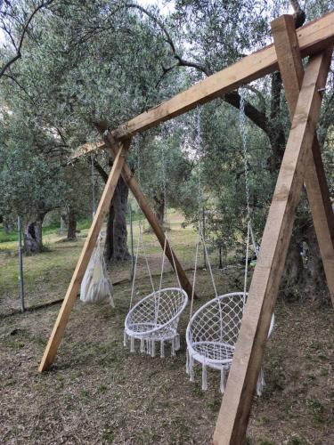 a swing set with two chairs in a park at OLEA COTTAGE in Ulcinj
