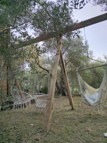 a group of chairs and hammocks in a yard at OLEA COTTAGE in Ulcinj