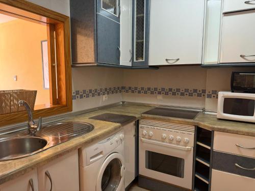 a kitchen with a sink and a washing machine at Sunset Beach Front in Almerimar