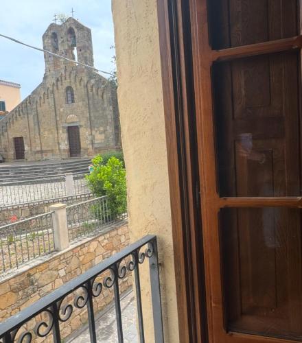 a door to a balcony with a church in the background at DiamanteSardo camera e bagno privato in Villamar