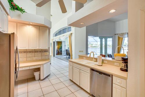 a large kitchen with white cabinets and a large window at Pool, Spa and Dock Waterfront Tarpon Point Home in Cape Coral