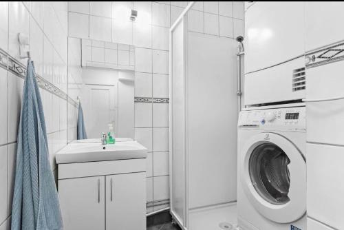 une salle de bain blanche avec une machine à laver et un lavabo dans l'établissement Hyggehuset, à Bergen