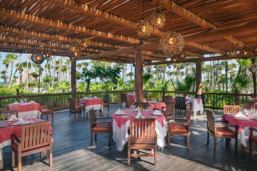 a restaurant with tables and chairs and chandeliers at Valentin Imperial Riviera Maya All Inclusive - Adults Only in Puerto Morelos