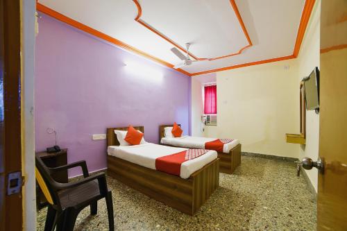 deux lits dans une chambre aux murs violets dans l'établissement Hotel O Radika Residency, à Warangal
