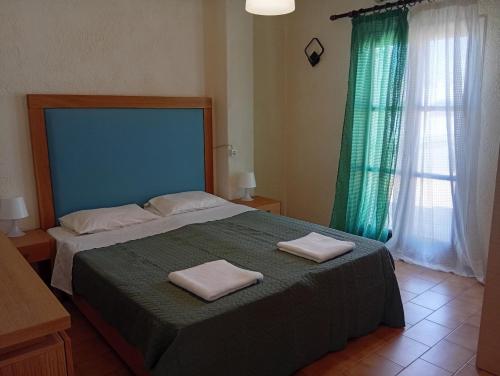 a bedroom with a large bed with two towels on it at Malia central apartments #2 in Malia