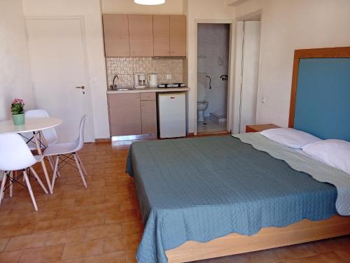 a bedroom with a bed and a table and a kitchen at Malia central apartments #2 in Malia