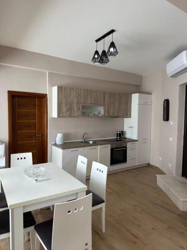 a kitchen and dining room with a white table and chairs at La Mer Beach Residence in Ulcinj