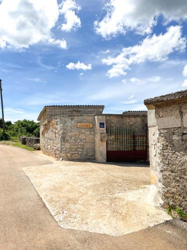 an old stone building with a gate on the side at Apartment Trsina in Rakalj