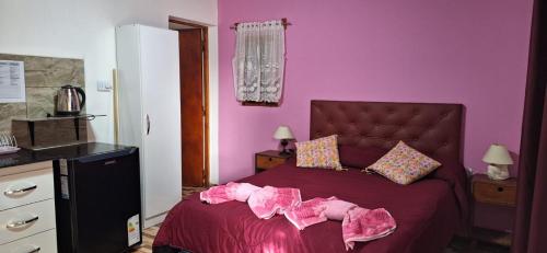 a purple bedroom with a bed with pink walls at Departamento Sol del Valle 1 in Fiambala